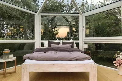 Ein Bett oder Betten in einem Zimmer der Unterkunft Glashaus Sternblick, Schlafen unterm Sternenhimmel